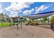 Community playground featuring slides, swings, and sunshades at 16313 Birchwood Way, Orlando, FL 32828