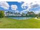 Outdoor tennis court with green fencing in a well-maintained community at 16313 Birchwood Way, Orlando, FL 32828