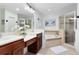 Bright bathroom featuring double sinks, a soaking tub, and a glass-enclosed shower at 171 Mcleods Way, Winter Springs, FL 32708