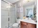 Well-lit bathroom featuring a glass-enclosed shower, decorative wall art, and a wood vanity at 171 Mcleods Way, Winter Springs, FL 32708