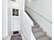 Bright, airy hallway featuring a staircase with white banister and a stylish accent window above the front door at 171 Mcleods Way, Winter Springs, FL 32708
