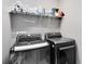 Functional laundry room featuring front-loading washer and dryer, and overhead storage shelf at 171 Mcleods Way, Winter Springs, FL 32708