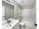 Well-lit bathroom features shower-tub combo and updated modern vanity, toilet, and mirror at 17505 Silver Creek Ct, Clermont, FL 34714