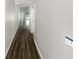 Inviting hallway with wood-look flooring and neutral paint, leading to various rooms in the home at 17505 Silver Creek Ct, Clermont, FL 34714