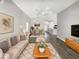 Bright living room with modern decor, ceiling fan, and an open concept layout to the dining and kitchen area at 17505 Silver Creek Ct, Clermont, FL 34714
