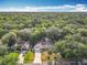 Aerial view of a neighborhood with lush green trees and single-story homes at 185 Poinciana Ln, Deltona, FL 32738