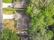 Aerial view of home with mature trees, a long driveway, and backyard waterfront access at 185 Poinciana Ln, Deltona, FL 32738