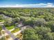 Aerial view of a neighborhood with lush green trees, single-story homes, and a street view at 185 Poinciana Ln, Deltona, FL 32738