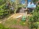 Backyard featuring boats, a treehouse, and a partially screened patio at 185 Poinciana Ln, Deltona, FL 32738