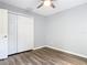 This bedroom features modern gray walls, wood flooring, and a closet with white bi-fold doors at 185 Poinciana Ln, Deltona, FL 32738