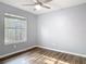Bright bedroom showcasing a ceiling fan, wood floors, and large window at 185 Poinciana Ln, Deltona, FL 32738