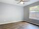 This bedroom features modern gray walls, wood flooring, and a window providing natural light at 185 Poinciana Ln, Deltona, FL 32738