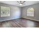Bright bedroom with a ceiling fan, hardwood floors, and large windows at 185 Poinciana Ln, Deltona, FL 32738