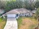 Charming single-story home featuring a well-manicured lawn, a two-car garage, and beautiful landscaping at 185 Poinciana Ln, Deltona, FL 32738