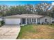 Single-story home featuring a two-car garage and landscaping at 185 Poinciana Ln, Deltona, FL 32738