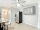 Bright kitchen area with stainless steel refrigerator, overhead cabinets, and barstool seating at 185 Poinciana Ln, Deltona, FL 32738