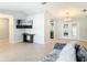Neutral living room featuring tile flooring, vaulted ceilings, and a modern entertainment area with a large screen TV at 185 Poinciana Ln, Deltona, FL 32738