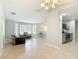 Open-concept living area with a stylish chandelier, tile flooring, and access to the kitchen with stainless steel appliances at 185 Poinciana Ln, Deltona, FL 32738