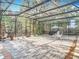 The screen-enclosed patio features a paved stone deck surrounded by lush tropical landscaping at 185 Poinciana Ln, Deltona, FL 32738