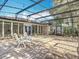 Open screened patio with brick flooring, white chairs, and a bright view to the backyard at 185 Poinciana Ln, Deltona, FL 32738
