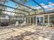 Large screened patio with a brick floor, potted plants and seating, ideal for outdoor enjoyment at 185 Poinciana Ln, Deltona, FL 32738