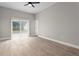 Bright bedroom with a ceiling fan, light grey walls, and sliding glass door to the backyard at 1862 Spreakley Ct, Orlando, FL 32837