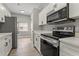 Modern kitchen features white cabinets, stainless steel appliances, and wood-look flooring at 1862 Spreakley Ct, Orlando, FL 32837