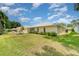 Picturesque backyard showcasing a well-kept lawn, charming garden, and the home's inviting exterior at 21529 Prince Albert Ct, Leesburg, FL 34748