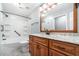 Bathroom with wood cabinet vanity, shower-tub combination, and new countertops and fixtures at 21529 Prince Albert Ct, Leesburg, FL 34748
