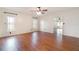 Spacious bedroom featuring a ceiling fan, hardwood floors, and abundant natural light from multiple windows at 21529 Prince Albert Ct, Leesburg, FL 34748