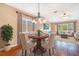 Elegant dining area featuring hardwood floors, stylish furniture, and views into the living room at 21529 Prince Albert Ct, Leesburg, FL 34748