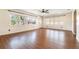Open-concept living room featuring wood flooring and multiple windows, providing lots of natural light at 21529 Prince Albert Ct, Leesburg, FL 34748