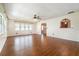 Bright living room with wood floors and a fan, with an arched opening in the wall, leading into another room at 21529 Prince Albert Ct, Leesburg, FL 34748
