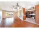 Living room featuring hardwood floors, a modern chandelier, and adjacent kitchen at 21529 Prince Albert Ct, Leesburg, FL 34748