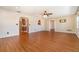 A spacious living room with wood floors, multiple windows, and an arched opening to another room at 21529 Prince Albert Ct, Leesburg, FL 34748