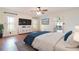 Spacious main bedroom featuring a plush bed, large windows, hardwood floors, and a ceiling fan at 21529 Prince Albert Ct, Leesburg, FL 34748