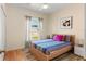 Cozy bedroom with light wood floors, ceiling fan, and colorful bedding offers a relaxing retreat at 235 Hollingshead Loop, Davenport, FL 33896