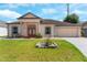 Charming single-story home with landscaped front yard, columns, and a two-car garage at 235 Hollingshead Loop, Davenport, FL 33896