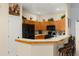 Well-lit kitchen featuring oak cabinets, black appliances, and a breakfast bar with seating at 235 Hollingshead Loop, Davenport, FL 33896