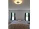 Cozy bedroom with natural light from two windows, features a floral-patterned bedspread at 25618 Fishermans Rd, Paisley, FL 32767