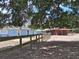 Exterior view showcasing a light blue house with a wooden fence and barn, shaded by trees at 25618 Fishermans Rd, Paisley, FL 32767