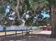 Property view with a light blue house, complemented by a wooden fence, barns, and mature trees at 25618 Fishermans Rd, Paisley, FL 32767