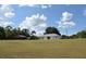 Wide view showcases the expansive yard and charming residence with a nearby red barn at 25618 Fishermans Rd, Paisley, FL 32767