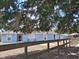 Single-story home with light blue exterior, framed by trees and a wooden fence, offers privacy and charm at 25618 Fishermans Rd, Paisley, FL 32767