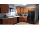 Functional kitchen with wood cabinets, laminate countertops, and modern black appliances at 25618 Fishermans Rd, Paisley, FL 32767