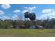 Beautiful pasture features trees, water and grazing horses under a blue, cloudy sky at 25618 Fishermans Rd, Paisley, FL 32767