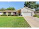Charming single-story home featuring a manicured lawn and an attached two-car garage at 307 Coble Dr, Longwood, FL 32779