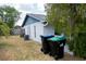View of the home's backyard showing the exterior paint and landscaping with trash bins at 3154 Stonecastle Rd, Orlando, FL 32822