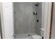 A remodeled bathroom featuring gray tiled walls, a hexagon-tiled shower floor, and a modern shower head fixture at 3154 Stonecastle Rd, Orlando, FL 32822