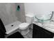 This renovated bathroom features gray-tiled walls, a hexagon-tiled shower floor, and a modern glass vessel sink at 3154 Stonecastle Rd, Orlando, FL 32822
